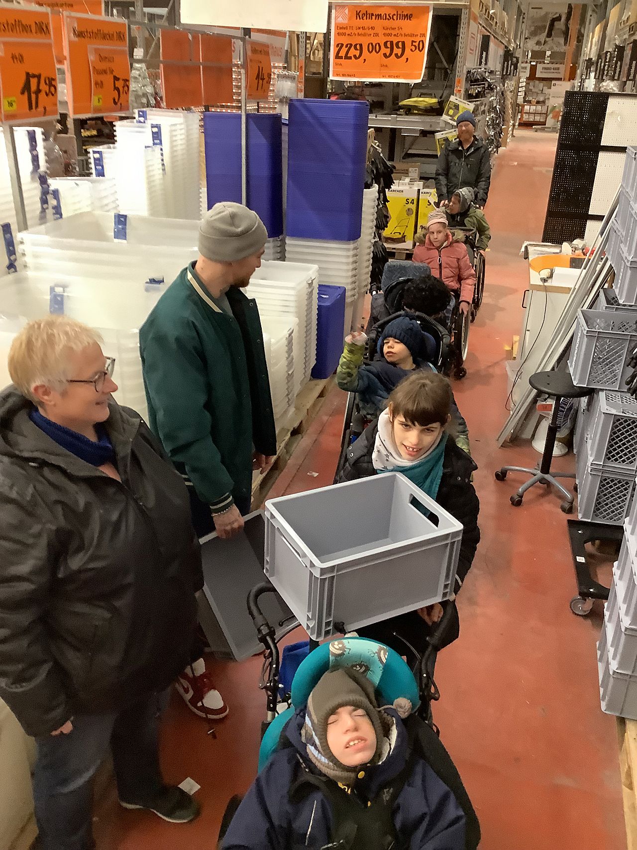 Die Schüler:innen stehen in einer Schlange und transportieren Euro-Boxen zum Wagen.