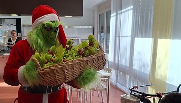 Der Grinch verteilt Nikolaustüten in der Kantine.