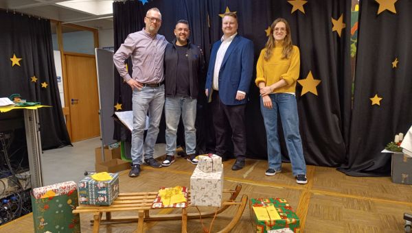 Mitglieder des Betriebsrats der Firma Mahle. Im Vordergrund sind ein Schlitten und Weihnachtsgeschenke zu sehen.