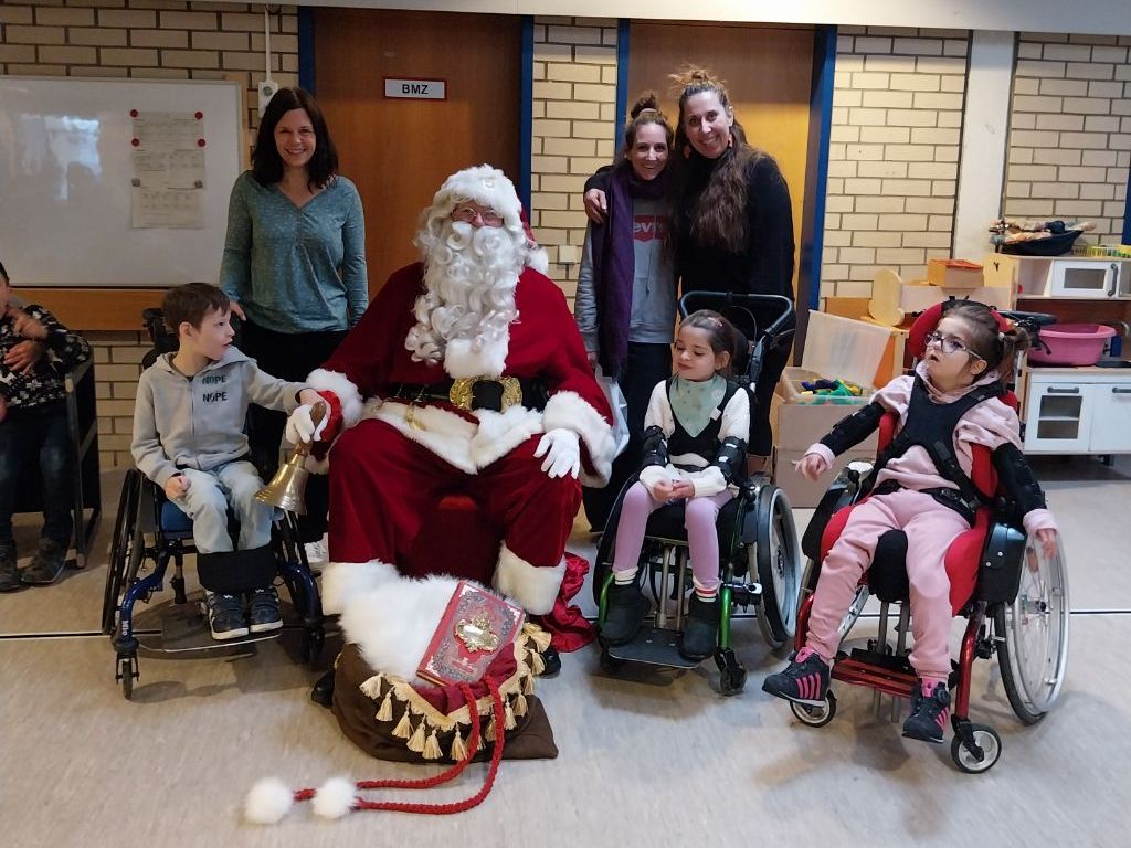 Weihnachtsmann mit drei Schülern und Lehrerinnen