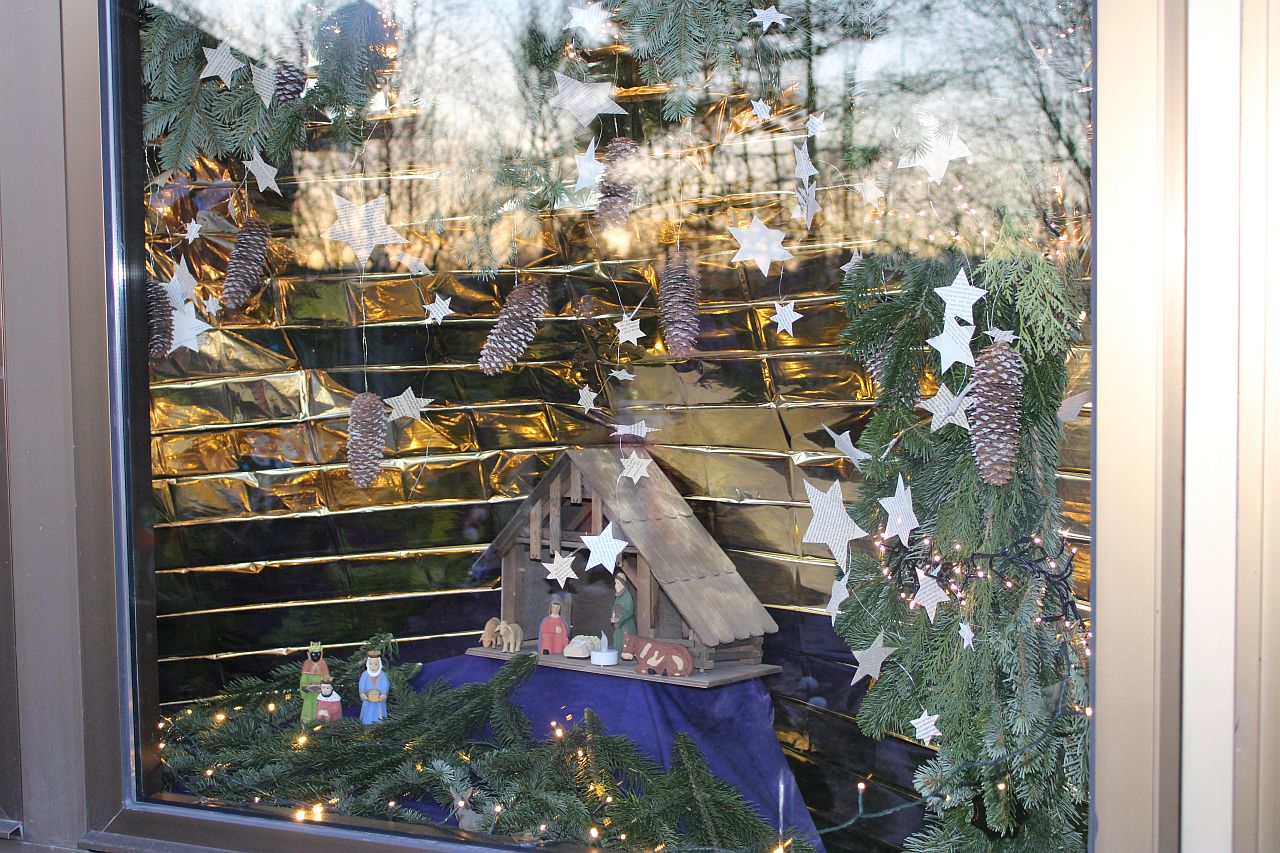 Eine Weihnachtsgrippe steht in einem schön geschmückten Fenster