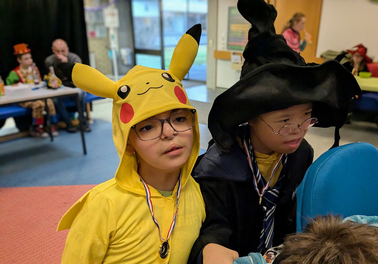 Ein Junge in einem Pikachu Kostüm und ein Junge in einem Zaubererkostüm stehen nebeneinander. 