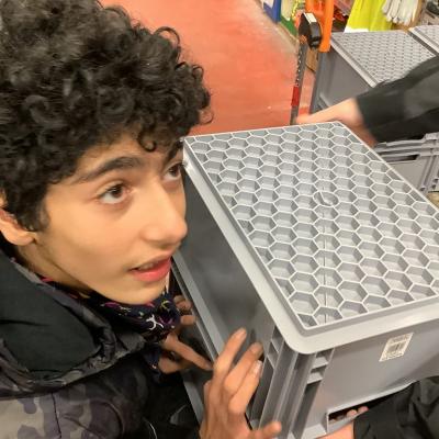 Melik stellt eine Box auf den Wagen.