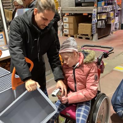 Fiona scannt mit Herrn Kling an der Selbstbedienungskasse eine Kiste.