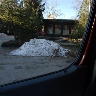 Man sieht einen kleinen Haufen dreckigen Schnee aus dem Auto heraus fotografiert.
