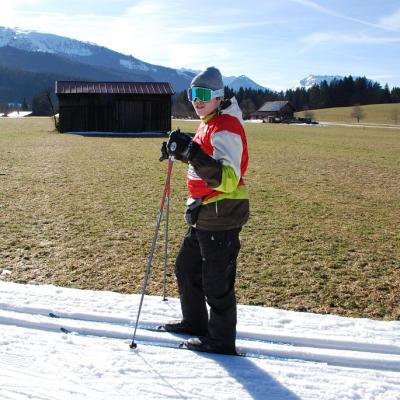 Julian läuft in der Loipe. Hinter der Loipe sieht man grüne Wiese.