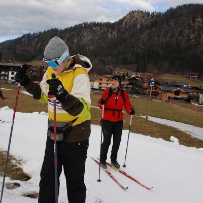 Julian und Frau Gauch laufen eine Schleife. Im Hintergrund sind traditionelle Häuser und Bergausläufer zu sehen.