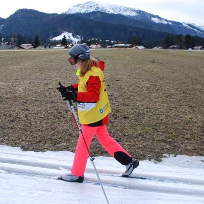 Lara läuft schwungvoll in der Loipe. Im Hintergrund sieht man einen schneebedeckten Berg.