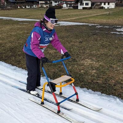 Marija läuft mit dem Skilator in der Loipe und lächelt.