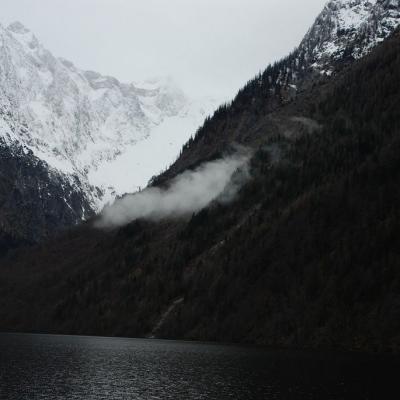 Über den See fällt der Blick auf die Ausläufer des Watzmann-Massivs. Der Gipfel ist von Wolken verdeckt.