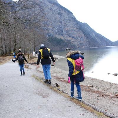 Julian und Lara balancieren über einen Baumstamm. Frau Fecke steht davor.