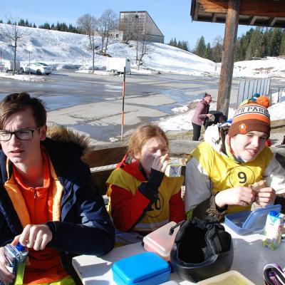 Florian, Lara und Julian sitzen am Tisch und essen ihr Lunch-Paket.