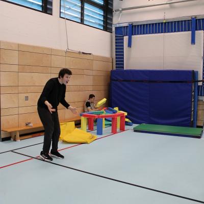 Ein Schüler spielt Basketball , der Ball ist sehr hoch geflogen 