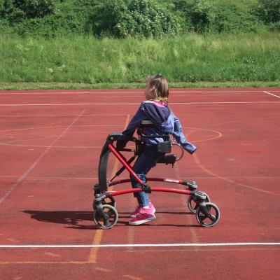 Eine Schülerin steht im Walker und wartet auf den Ball.