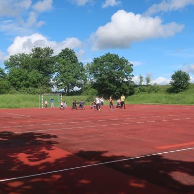 Hinten am großen Fußballfeld stehen die Spieler.