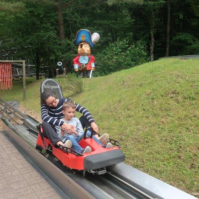Ein Schüler mit Betreuerin fahren die Sommerrodelbahn herunter