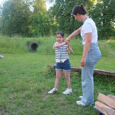 Eine Schülerin tanzt mit einer Betreuerin auf der Wiese
