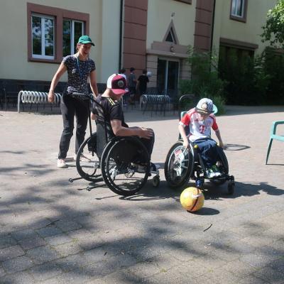 Zwei Rollstuhlfahrer spielen Fußball