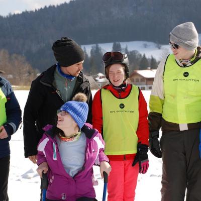 Christopher, Herr Kling, Marija, Lara, Julian und Josua stellen sich für das Gruppenfoto im Titelbild auf. Im Hintergrund sieht man ein großes Schneefeld und die schöne Landschaft mit dem guten Wetter.