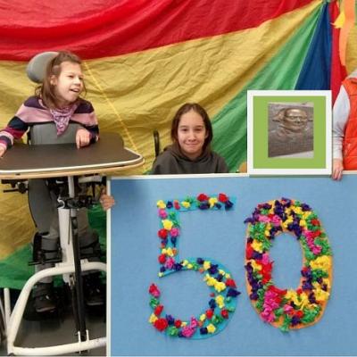 Auf dem Bild sind rechts und links zwei lachende Schüler im Stehständer. Dazwischen sieht man drei Mädchen. 