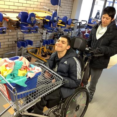 2 Schüler fahren mit einem Wagen Lappen durch einen Flur.