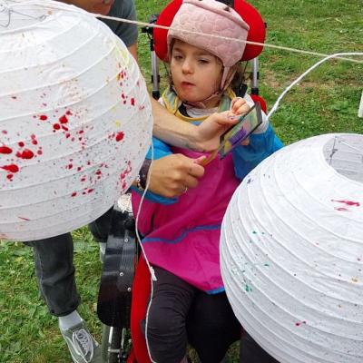 Eva spritzt bunte Farbe auf die Lampions.