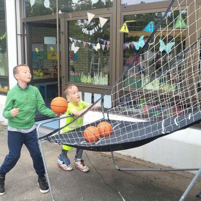 Samy und Yannic werfen die Basketbälle in den Korb.