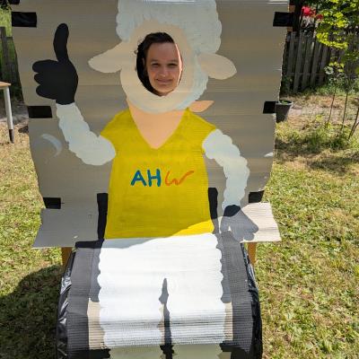 Eine Frau steht bei unserem neuen Schulmaskottchen und macht ein Foto. 