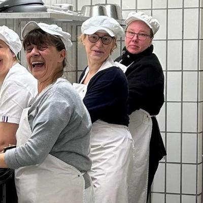 Die Mitarbeiterinnen der Großküche lachend bei der Arbeit