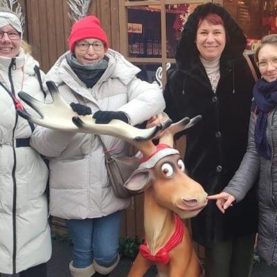 Die Mitarbeiterinnen der Großküche hinter einem Kunststoff-Elch, alle lachen