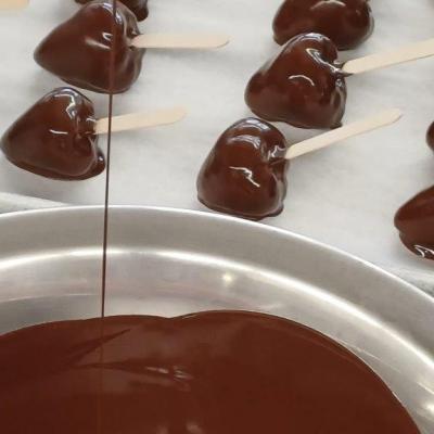 Ein Blech voll Erdbeeren die in Schokolade getaucht wurden