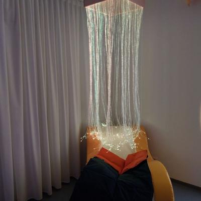 Unter der Lichterdusche steht ein Schaukelsessel mit einer Gewichtsdecke.