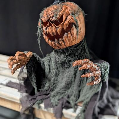 Ein gruseliger Kürbisaufsteller mit Armen steht auf einer Bank und konnte leuchten