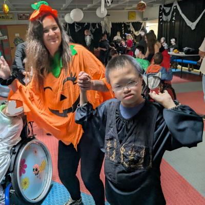 Ein verkleideter Junge und eine Frau lachen in die Kamera und haben Spaß auf der Tanzfläche