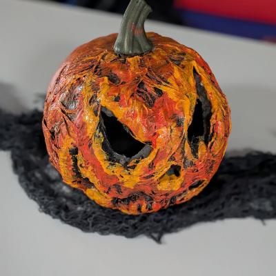 Ein gruseliger Kürbis steht auf dem Tisch