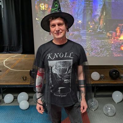 Ein Mann mit Zaubererkostüm lächelt in die Kamera