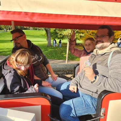 Zwei Schülerinnen und zwei Betreuer fahren mit der Bahn auf dem Killesberg.