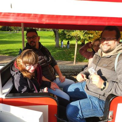 Zwei Schülerinnen und zwei Betreuer fahren mit der Bahn auf dem Killesberg.