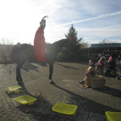 Sankt Martin auf dem Pferd vor dem als Bettler verkleideten Kind im Gegenlicht