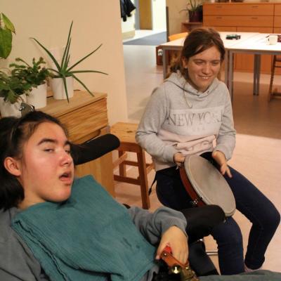 vier Hände die gemeinsam ein Schellenband halten 