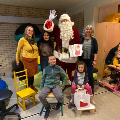 Gruppenfoto von zwei Schülerinnen mit drei Lehrkräften und Weihnachtsmann