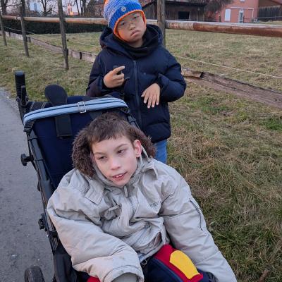 zwei Jungs stehen bei einem Feld und lachen in die Kamera