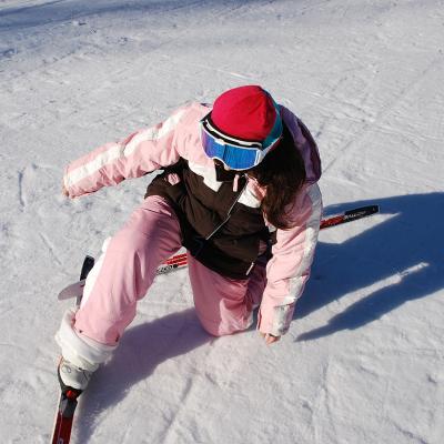 Sophia kniet mit einem Bein im Schnee. Das andere versucht sich aufzustellen, doch die Ski haben sich verhakt.
