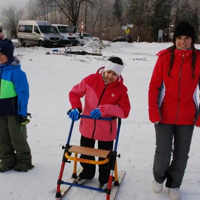 Luca, Ghofran mit Skilator und Lena stehen im Schnee und bewegen sich.