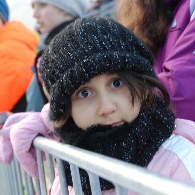 Sophia steht am Geländer und schaut mit großen Augen in die Kamera.