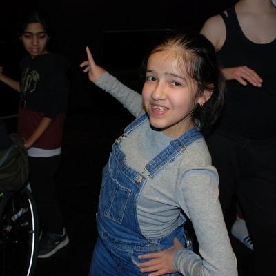 Ghofran tanzt im dunklen Disco-Raum und lächelt in die Kamera.