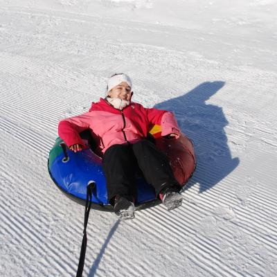 Ghofran sitzt in einem Reifen, der mit einem Seil von der Person, die das Foto macht, gezogen wird.