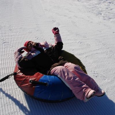 Sophia liegt scheinbar erschöpft in ihrem Reifen im Schnee.