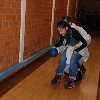 Ghofran rollt eine Kugel mit rechts. Sie sitzt dabei auf Frau Feckes Knie, die ihr bei der Aktion hilft.