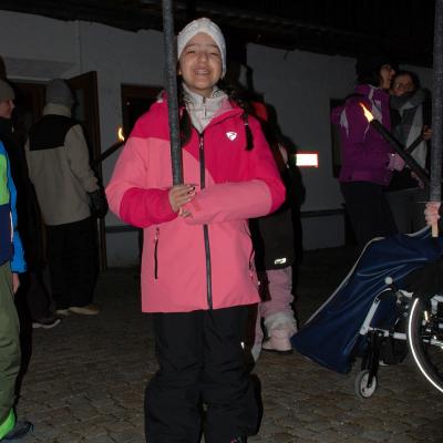 Ghofran hält mit beiden Händen eine schwarze brennende Fackel und grinst stolz in die Kamera.